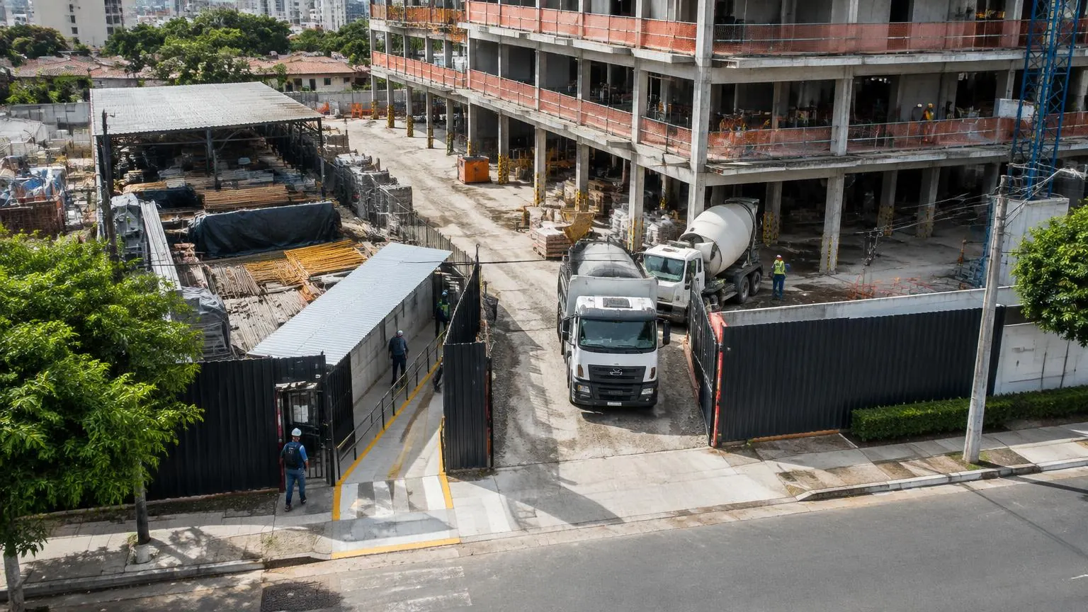 Canteiro de obras restrito em área urbana com acessos, depósitos e circulação organizados