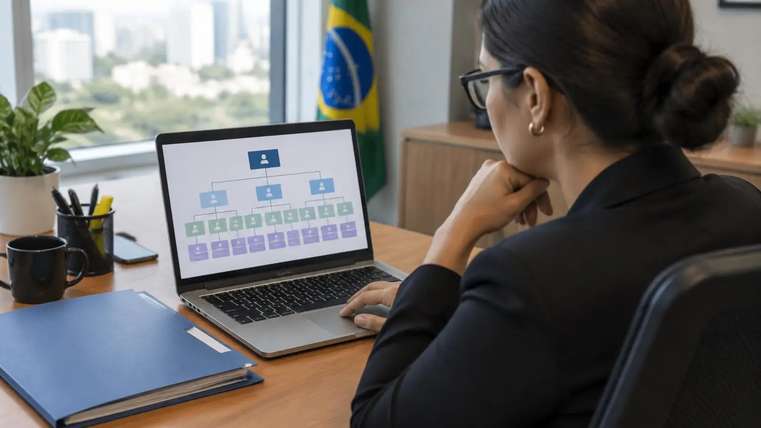 Gestora de recursos humanos revisando organograma da empresa no notebook, com pasta de documentos ao lado