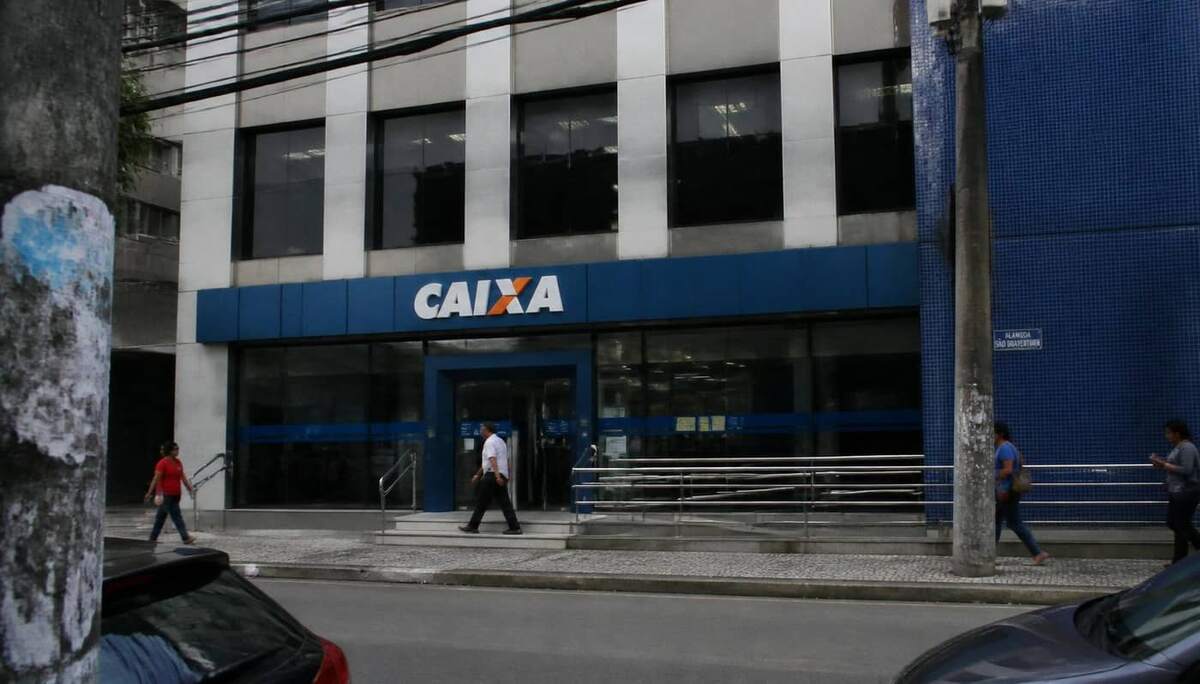 Trabalhadora em agência da Caixa Econômica Federal para atendimento sobre seguro desemprego